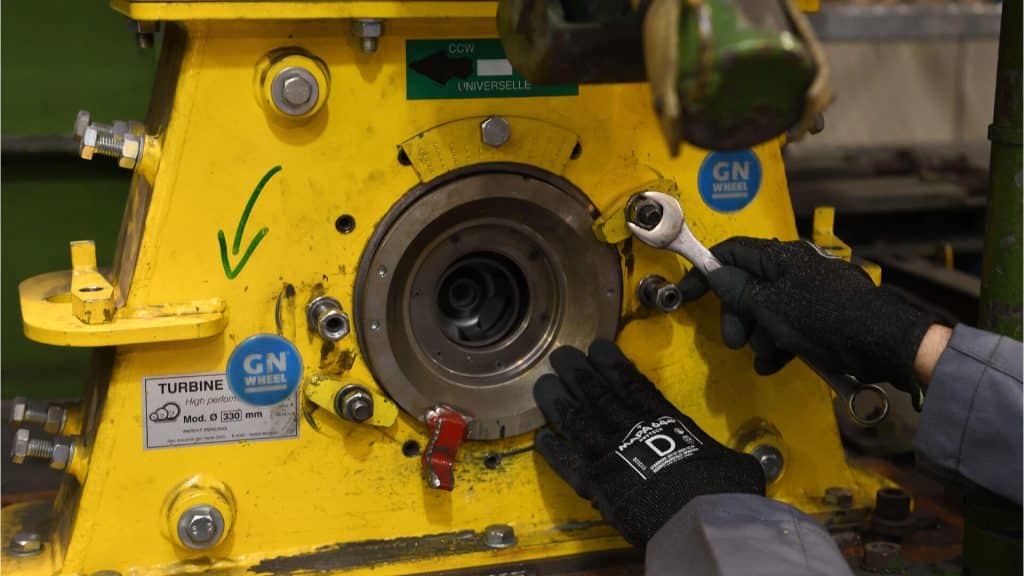 Technician performing maintenance on a shot blast wheel